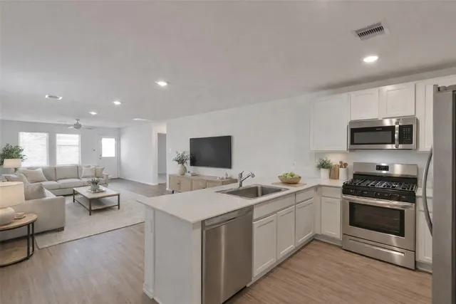 a kitchen with a refrigerator a microwave a sink and cabinets