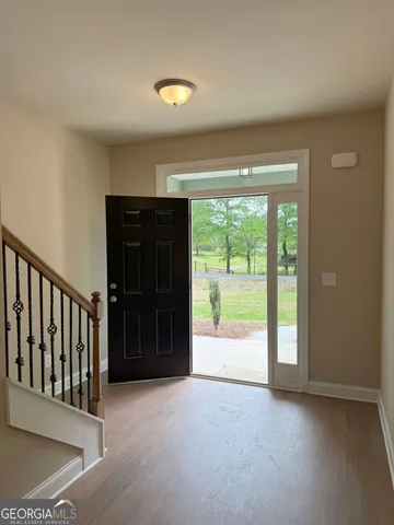 a view of a hallway with wooden floor and entryway