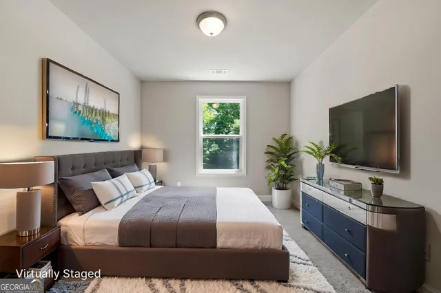 a spacious bedroom with a bed and a potted plant