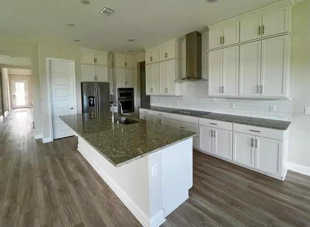 a kitchen with stainless steel appliances granite countertop a sink counter space and cabinets