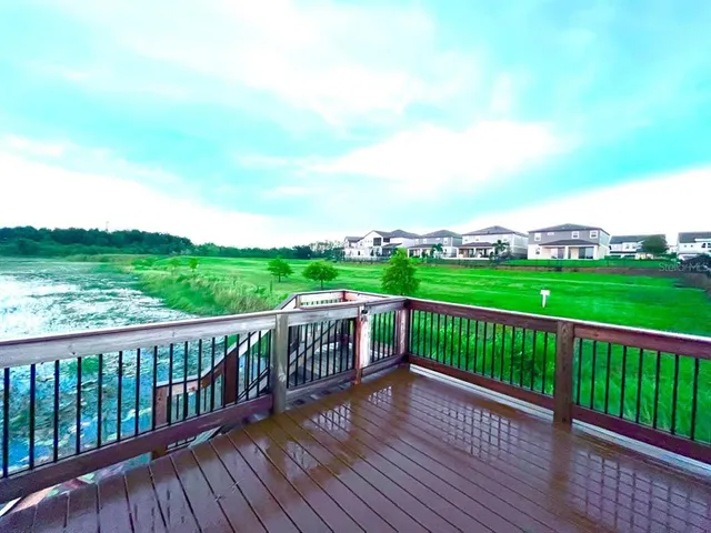 a view of a balcony with wooden floor and fence