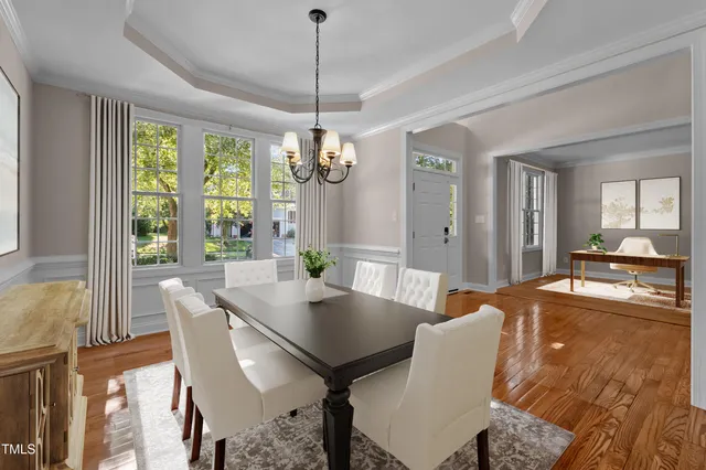 a view of a hallway with wooden floor and a chandelier