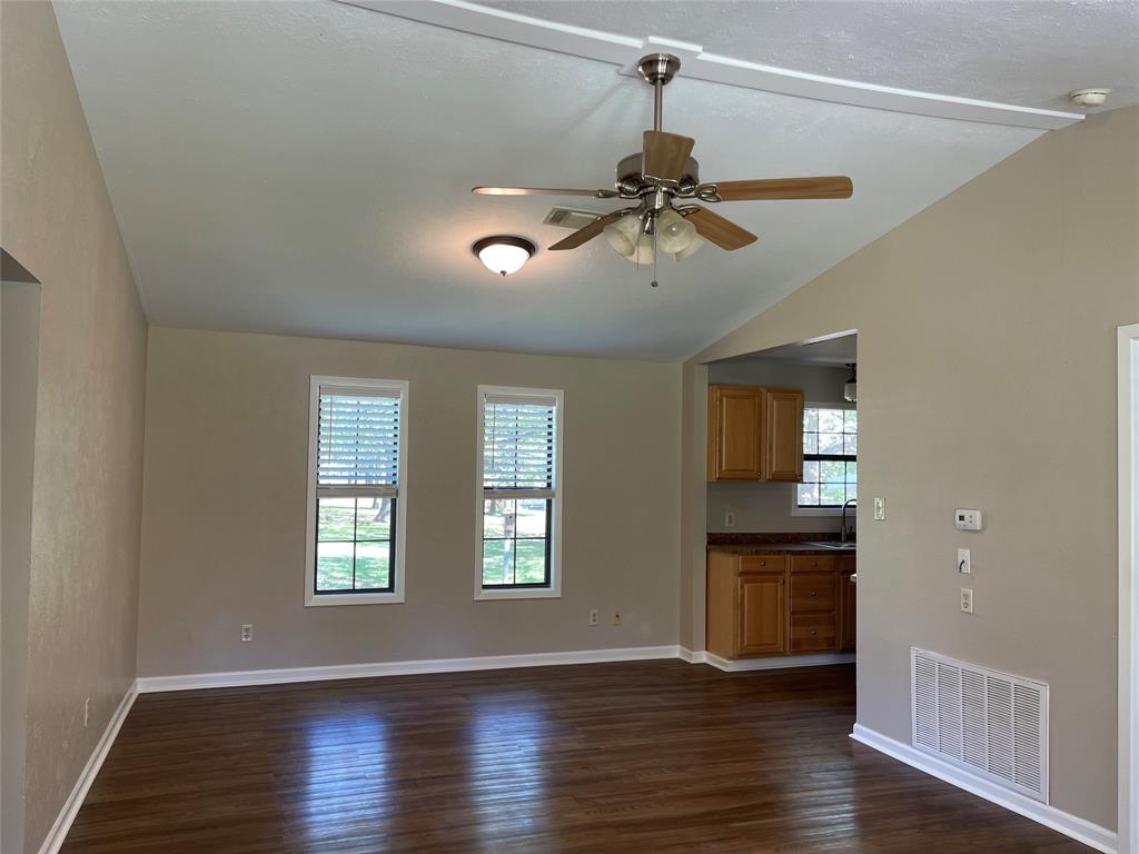 1509 Mitchell Drive Bonham, TX 75418 - Photo 2 of 9 a view of a room with a ceiling fan and wooden floor