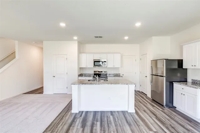 a kitchen with a refrigerator and a stove top oven