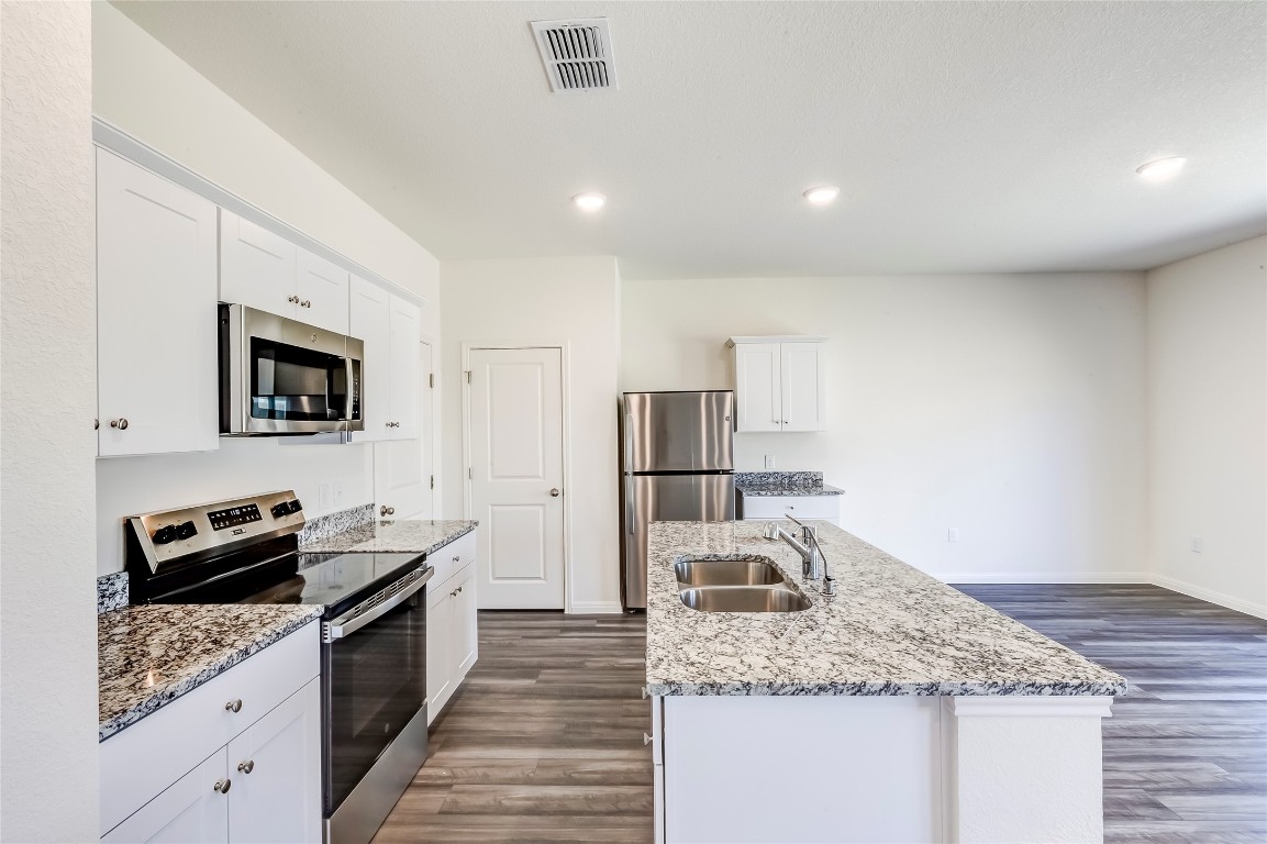 344 Enforcer Loop Jarrell, TX 76537 - Photo 13 of 34 a kitchen with stainless steel appliances granite countertop a sink stove and refrigerator
