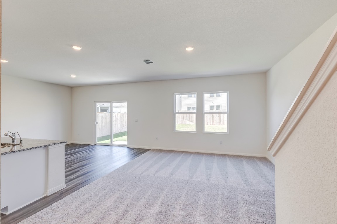 344 Enforcer Loop Jarrell, TX 76537 - Photo 7 of 34 an empty room with wooden floor and windows