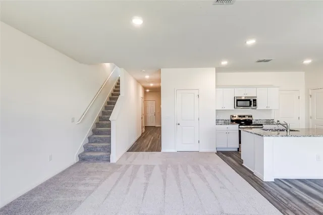 a view of a kitchen with wooden floor and electronic appliances