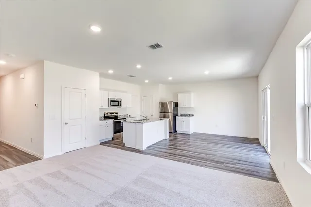 a view of kitchen with kitchen island sink refrigerator and window