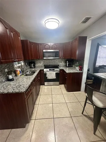 a kitchen with stainless steel appliances granite countertop wooden cabinets a sink and dishwasher
