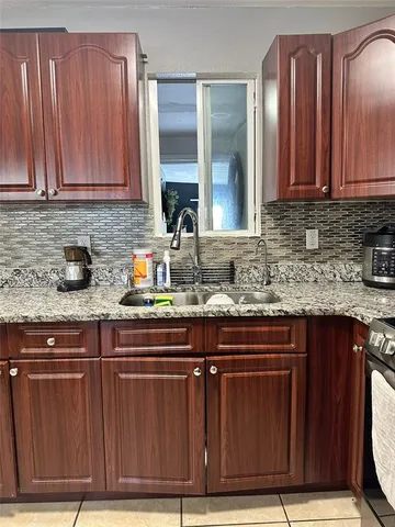a room with granite countertop furniture a rug and white walls