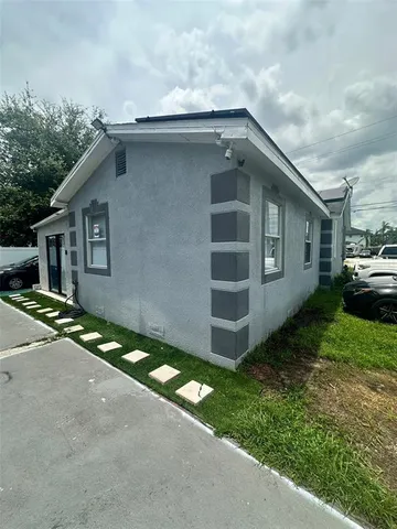 a front view of house with yard and trees in the background
