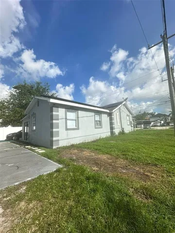 a view of a yard in front of a house with large tree