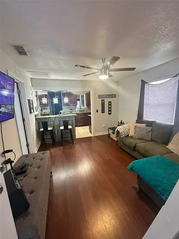 a living room with furniture and wooden floor