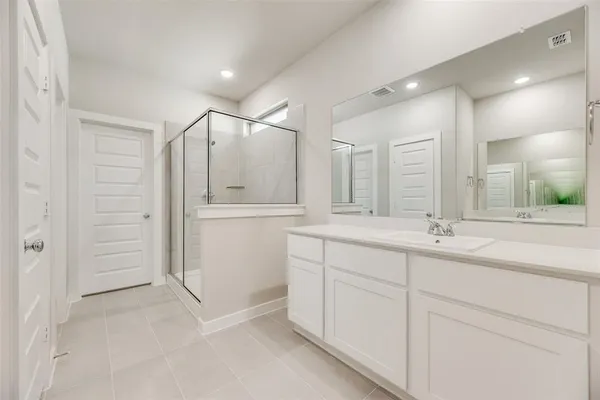 a bathroom with double vanity and a shower