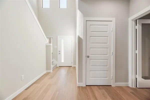 a view of a hallway with wooden floor and closet