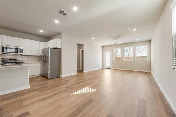 a view of kitchen with refrigerator microwave and stove top oven