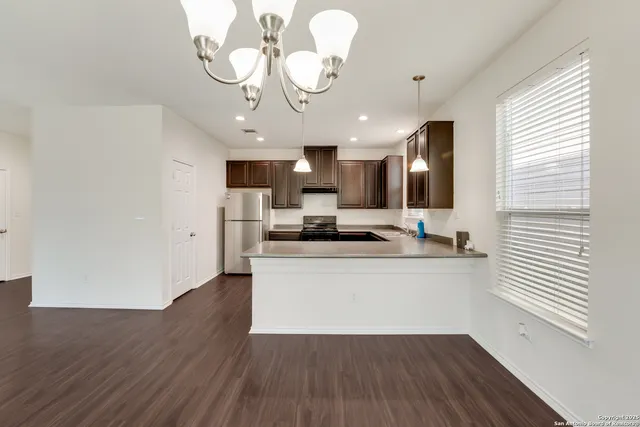 a large kitchen with stainless steel appliances granite countertop a lot of counter space and wooden floors