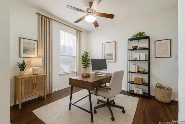 a view of a workspace with furniture and a window