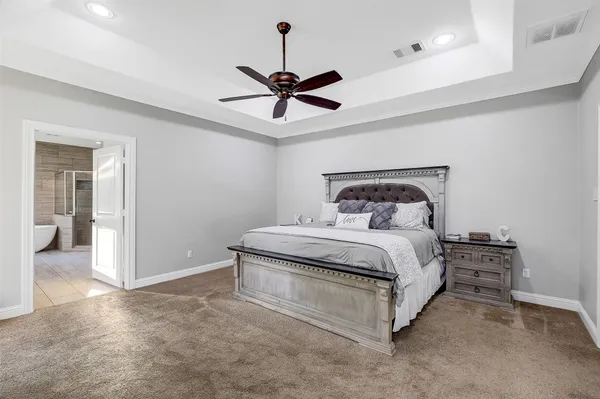 a bedroom with a bed a flat screen tv and couches