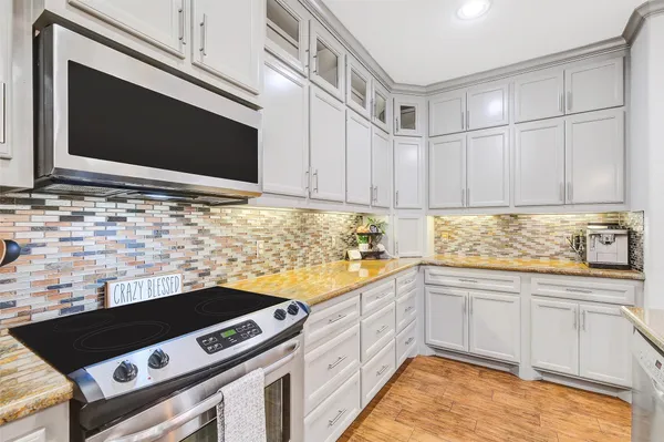 a bathroom with a granite countertop sink double vanity granite tub shower and a mirror