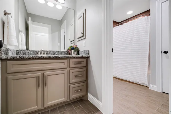 a bathroom with a granite countertop sink and a mirror