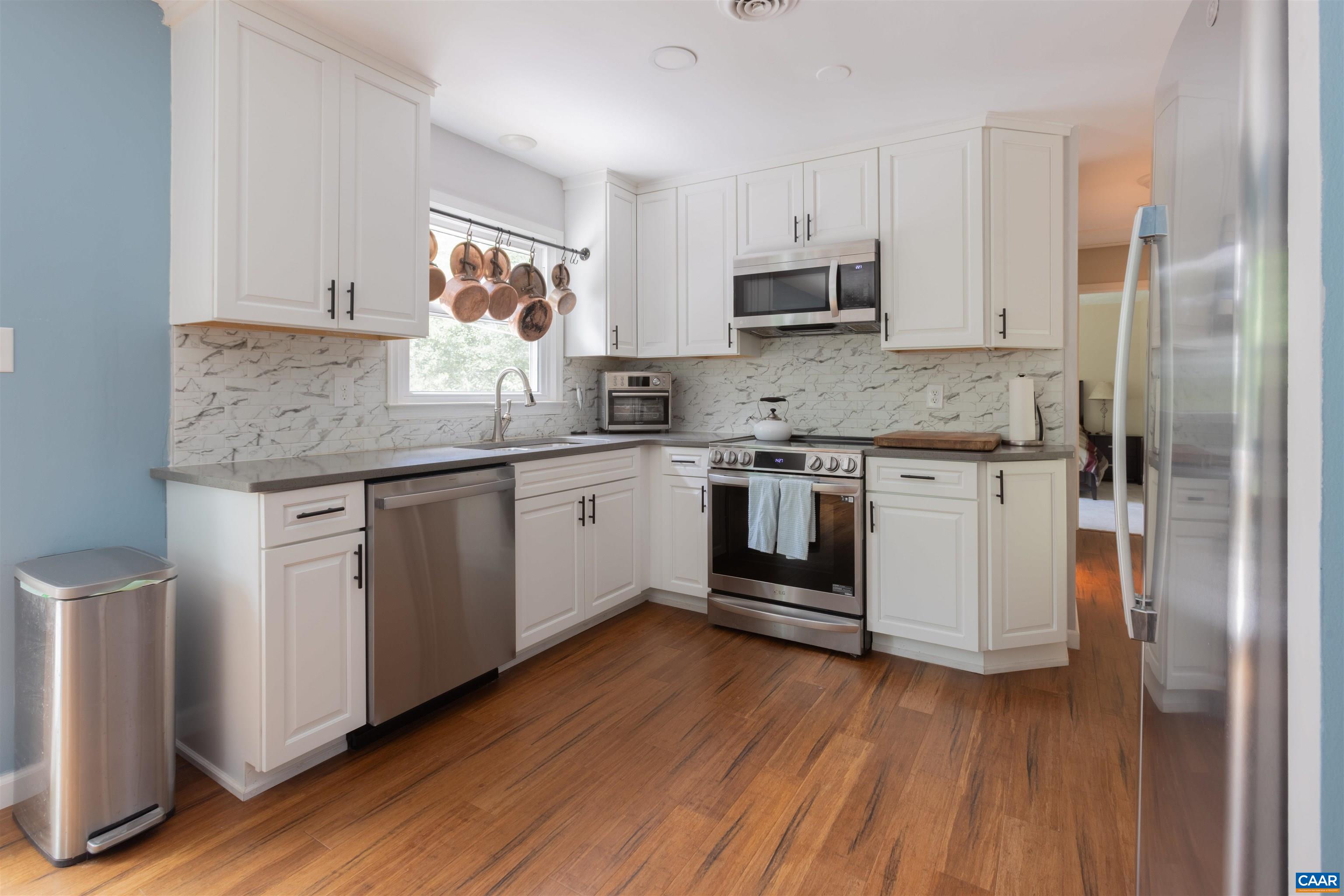 2550 Proffit Road Charlottesville, VA 22911 - Photo 6 of 41 a kitchen with stainless steel appliances granite countertop wooden floors and white cabinets
