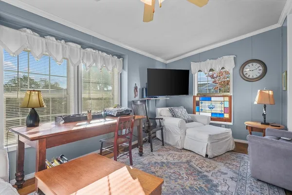 a living room with furniture a flat screen tv and a large window
