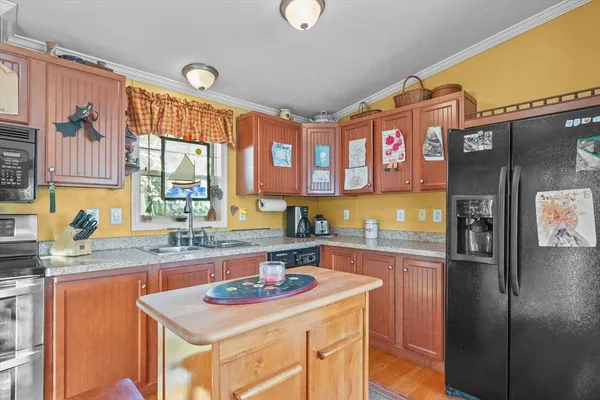 a kitchen with stainless steel appliances granite countertop a sink a stove and refrigerator
