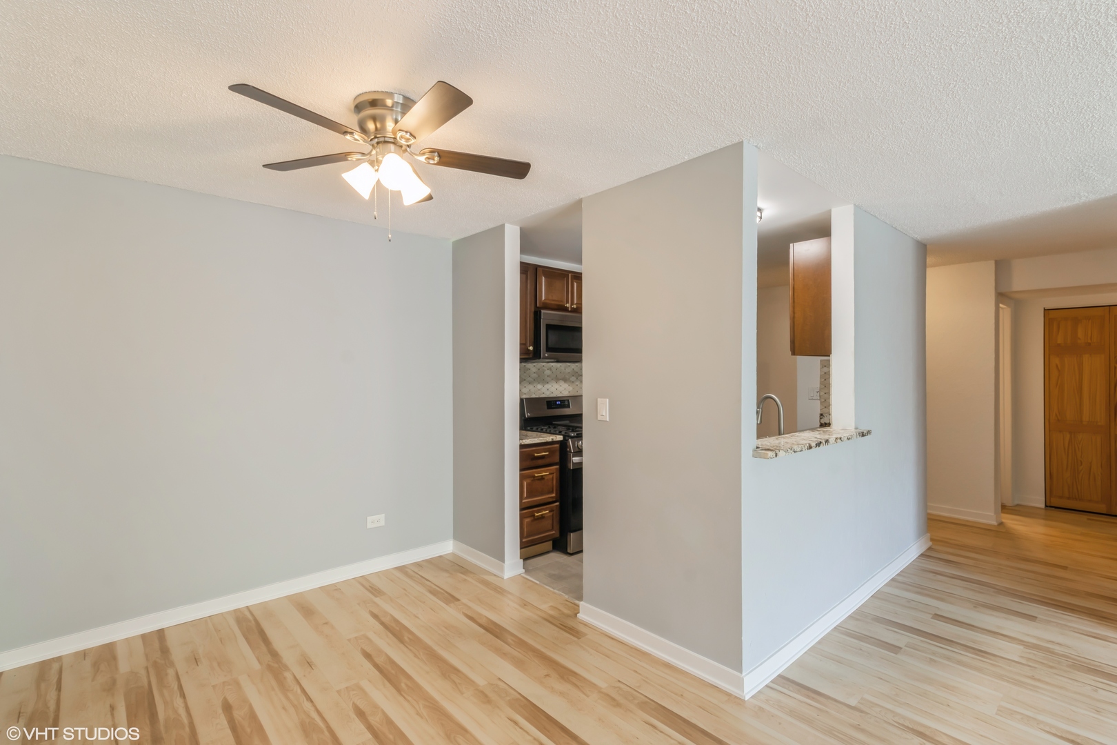 1926 Prairie Square, Unit 328 Schaumburg, IL 60173 - Photo 4 of 15 a view of an empty room with wooden floor and a ceiling fan