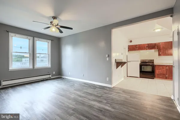 a view of a kitchen with wooden floor electronic appliances and windows