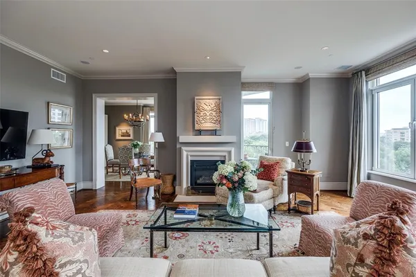 a living room with furniture a fireplace and a large window