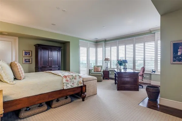 a bedroom with a large bed and windows