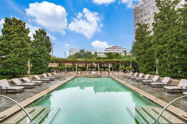 a view of a swimming pool with lounge chairs on th patio
