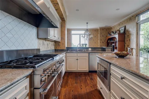 a kitchen with granite countertop a stove sink and cabinets