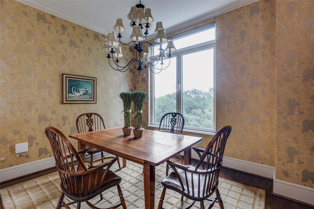 3505 Turtle Creek Boulevard, Unit 5A Dallas, TX 75219 - Photo 9 of 28 Dining room featuring wallpapered walls, ornamental molding, wood finished floors, and a chandelier