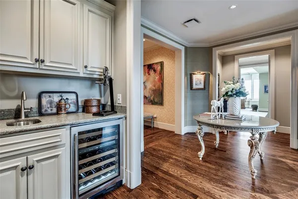 a living room with stainless steel appliances furniture a rug and a kitchen view