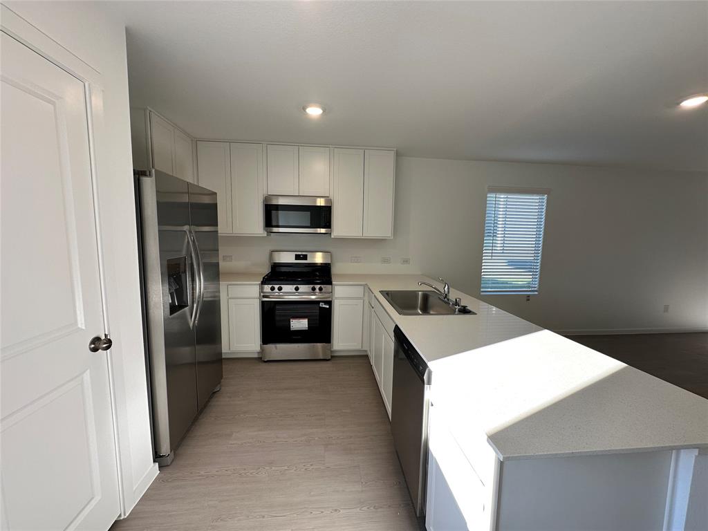 3928 Pontchartrain Parkway Sherman, TX 75090 - Photo 5 of 13 a kitchen with kitchen island a refrigerator sink and stove