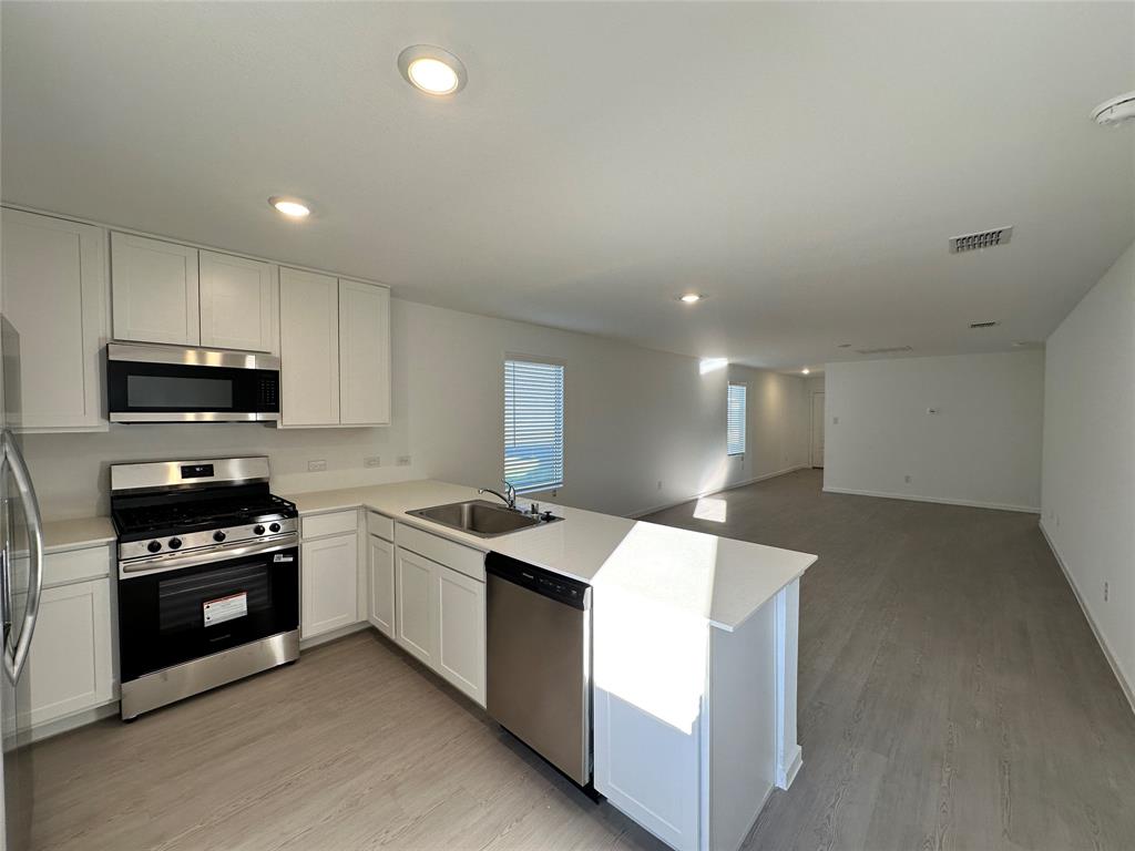 3928 Pontchartrain Parkway Sherman, TX 75090 - Photo 6 of 13 a kitchen with stainless steel appliances kitchen island granite countertop a sink stove and refrigerator