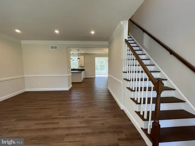 a kitchen with stainless steel appliances granite countertop a sink a stove a refrigerator and island with wooden floor