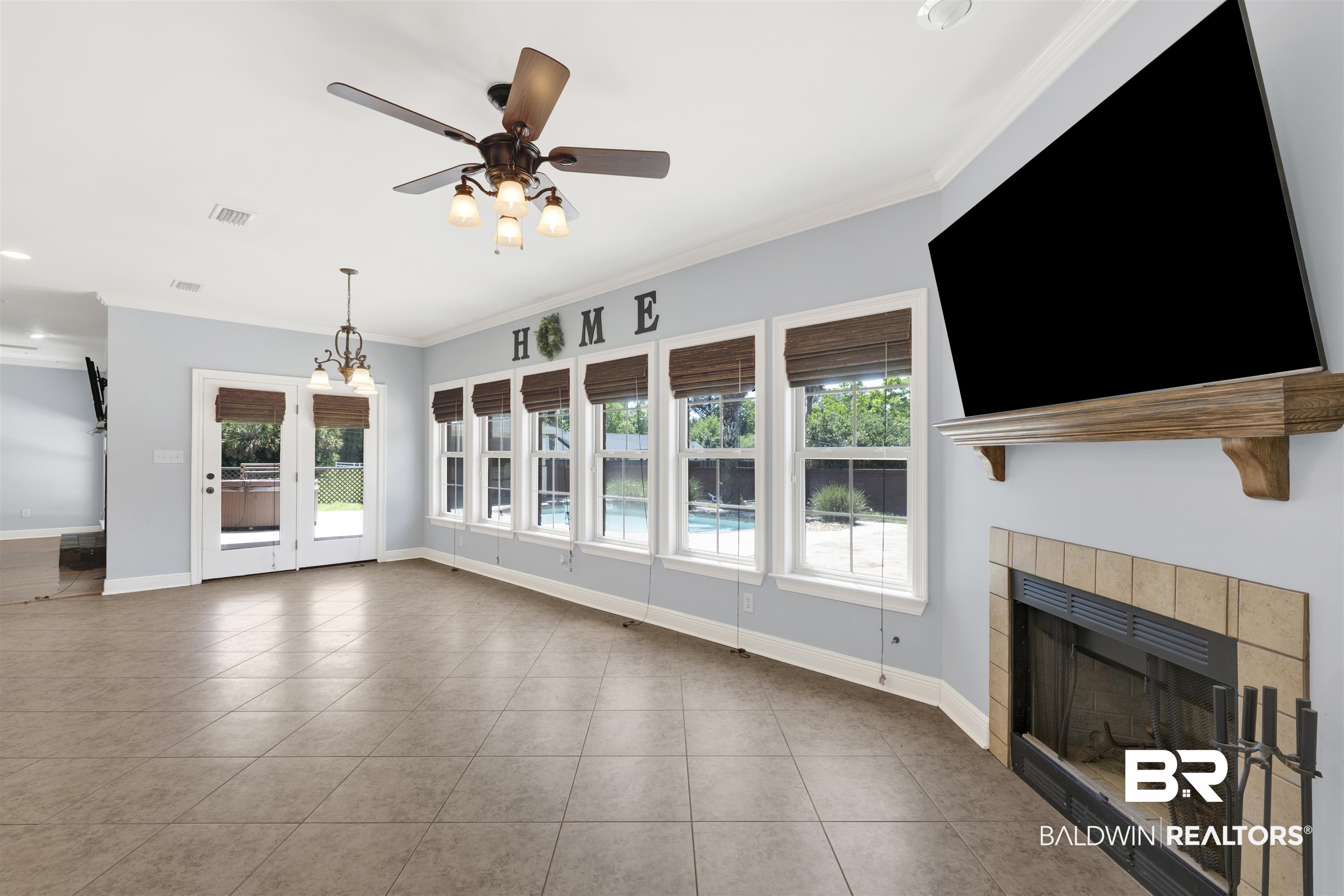 12944 Anna's Way Stapleton, AL 36578 - Photo 39 of 64 Spacious room featuring tile flooring, a fireplace with a tiled surround, a wood mantel, and multiple windows