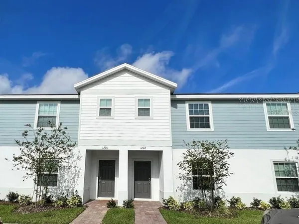a front view of a house with plants
