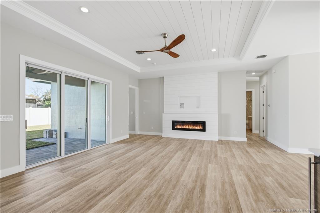1063 Northwest 12th Terrace Stuart, FL 34994 - Photo 13 of 42 a view of empty room with wooden floor and fireplace