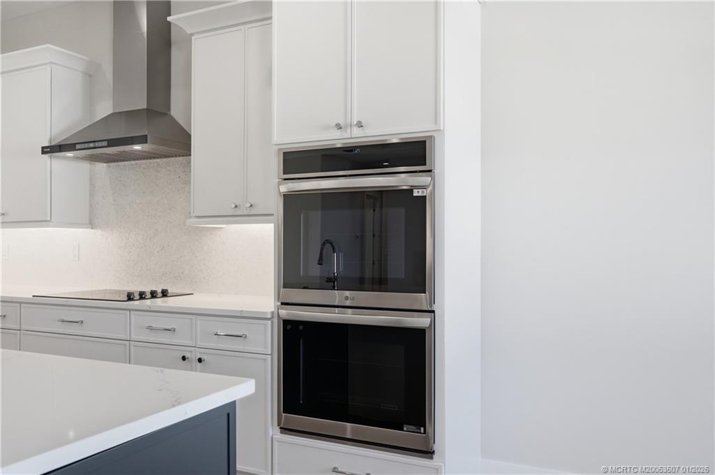 1063 Northwest 12th Terrace Stuart, FL 34994 - Photo 19 of 42 a kitchen with granite countertop white cabinets and stainless steel appliances