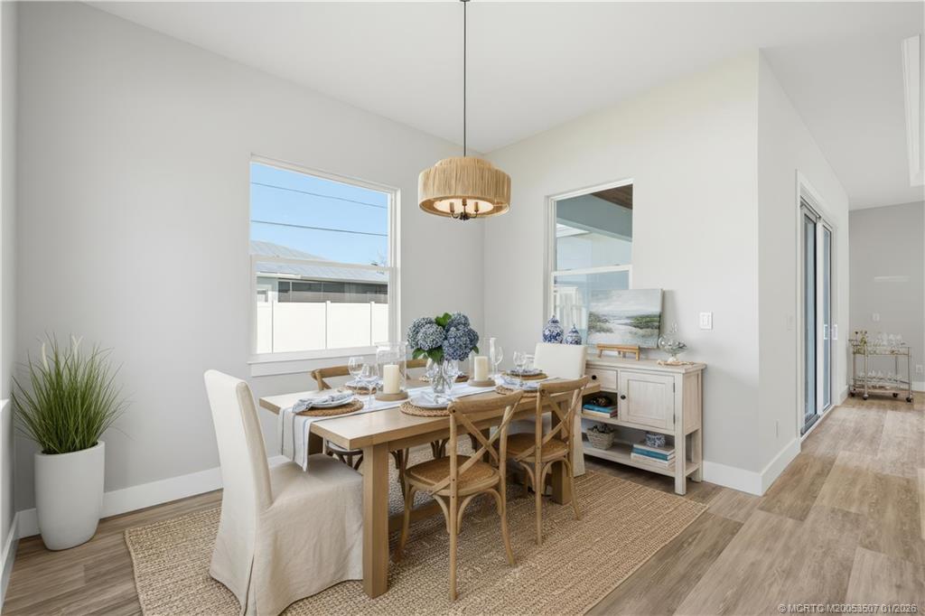1063 Northwest 12th Terrace Stuart, FL 34994 - Photo 20 of 42 a dining room with furniture potted plants and wooden floor