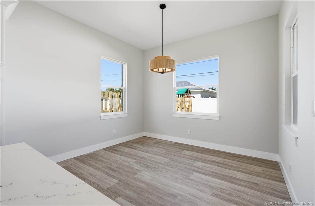 1063 Northwest 12th Terrace Stuart, FL 34994 - Photo 21 of 42 wooden floor in an empty room with a window