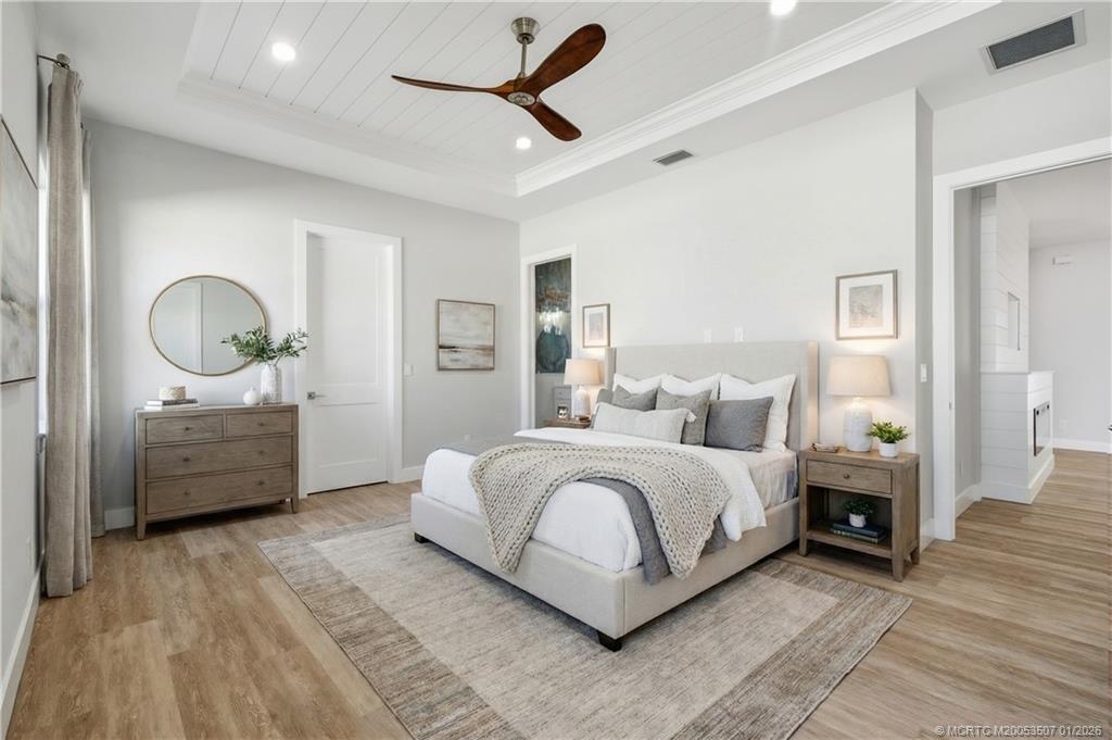 1063 Northwest 12th Terrace Stuart, FL 34994 - Photo 24 of 42 a spacious bedroom with a bed a mirror and a window