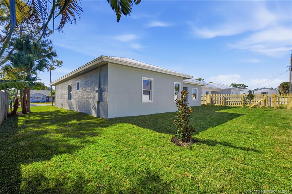 1063 Northwest 12th Terrace Stuart, FL 34994 - Photo 40 of 42 a backyard of a house with table and chairs