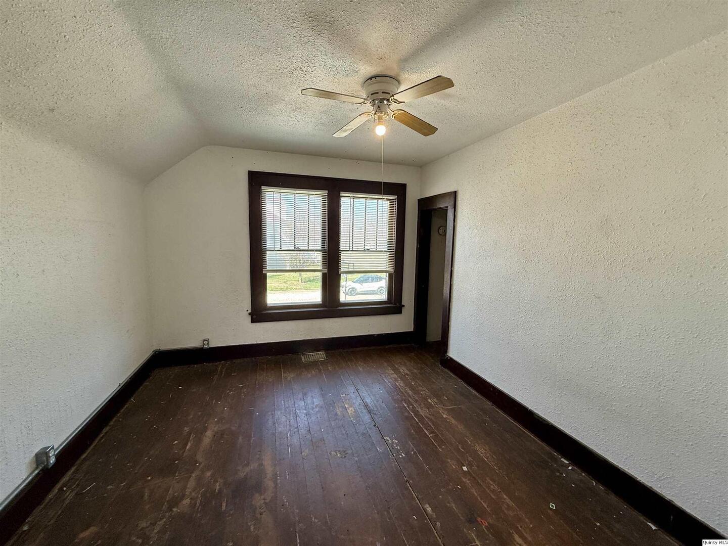 622 East Center Street Loraine, IL 62349 - Photo 19 of 21 an empty room with wooden floor chandelier fan and windows