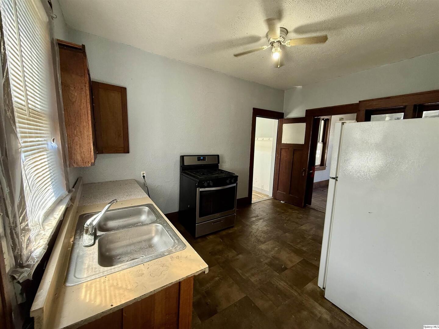 622 East Center Street Loraine, IL 62349 - Photo 8 of 21 a kitchen with stainless steel appliances granite countertop a refrigerator a stove and a sink with wooden floor
