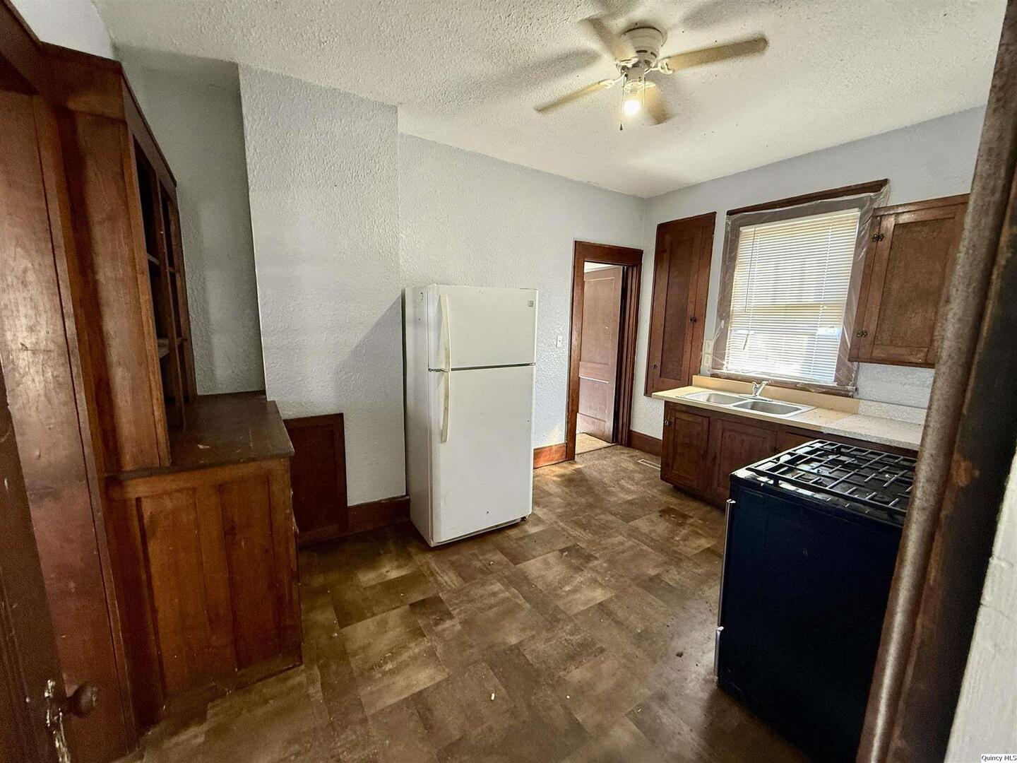 622 East Center Street Loraine, IL 62349 - Photo 9 of 21 a kitchen with granite countertop a refrigerator a stove a sink a washer dryer and white cabinets